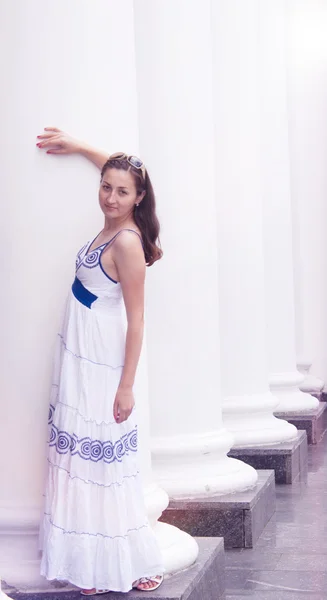 Όμορφο κορίτσι σε ένα μεγάλο λευκό στήλες κοντά τα φορέματα της σεζόν — Φωτογραφία Αρχείου