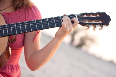 bir gitar çalmaya elbiseli bir kız