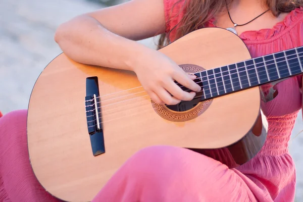 Una chica con un vestido tocando una guitarra — Foto de Stock