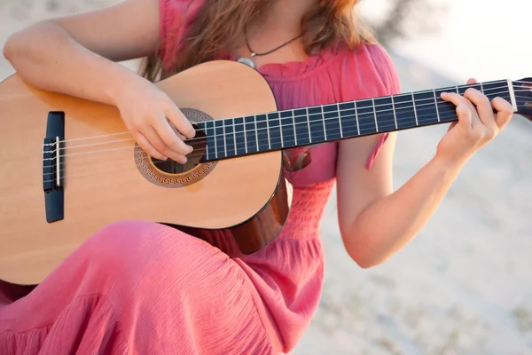 Une fille en robe jouant de la guitare — Photo