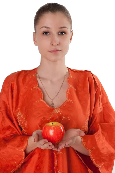 Mädchen im orangefarbenen Kleid bietet einen roten Apfel — Stockfoto