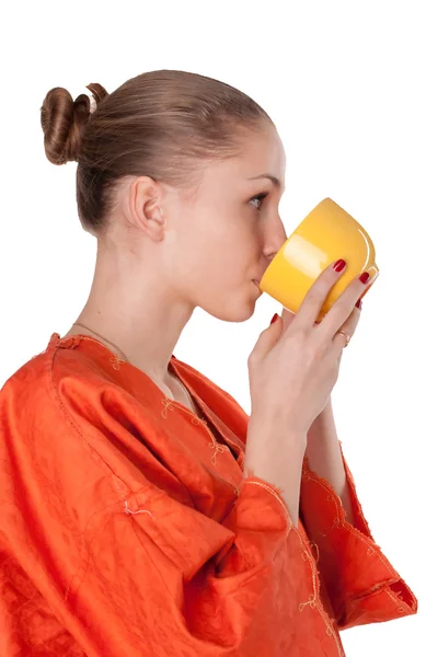 A rapariga de roupão laranja a beber chá — Fotografia de Stock