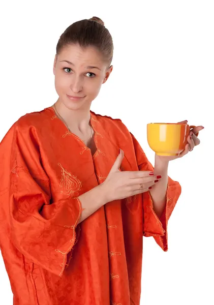 中的橙色长袍的女孩提供茶 — 图库照片