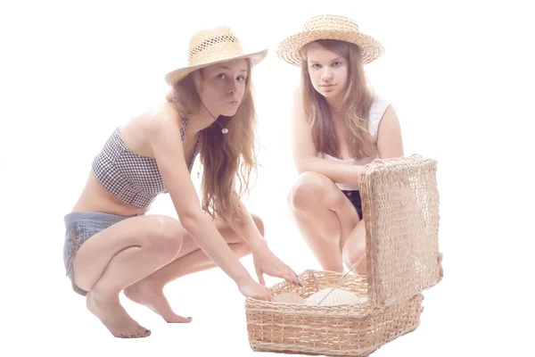 Δύο κορίτσια στο άχυρο καπέλα ψάθινο καπέλο με ένα άχυρο βαλίτσα — Φωτογραφία Αρχείου