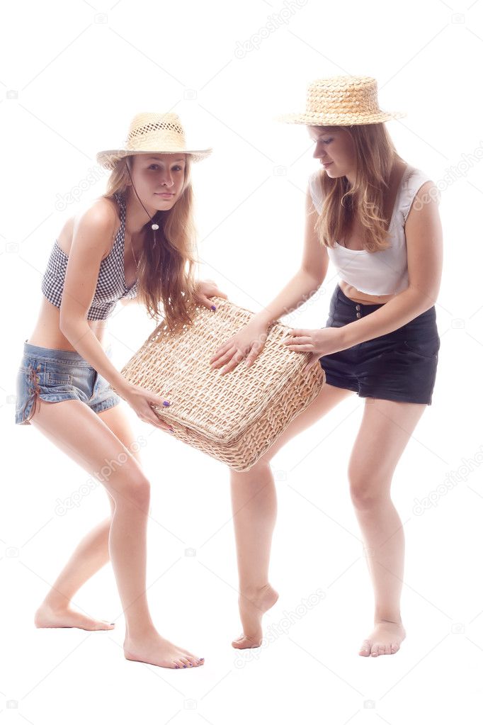 Two girls in straw hats with a straw suitcase