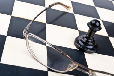 Pawn and glasses on a chessboard clipart