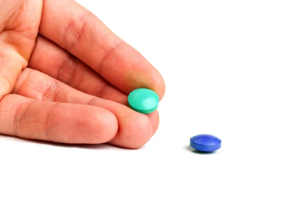 Green and blue tablets in hand — 스톡 사진