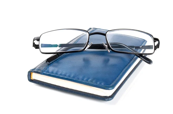 Caderno azul e óculos — Fotografia de Stock