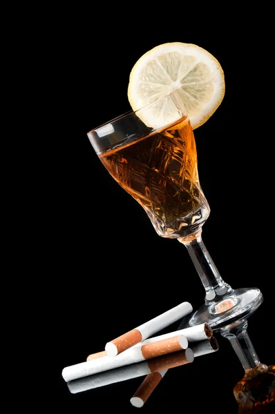 Cognac in a glass with lemon and cigarettes — Stock Photo, Image