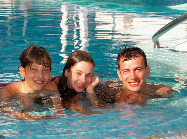 Familia feliz en la piscina Imagen de stock