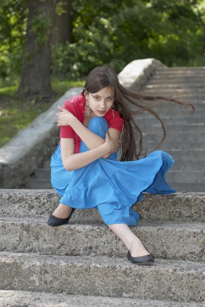 Beautiful young girl sitting on the stairs — Stock Photo, Image