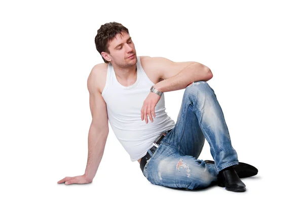 牛仔裤坐在一个孤立的背景上的男人 — 图库照片