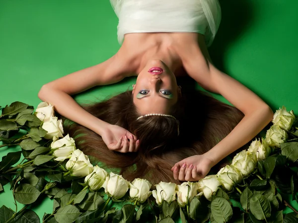 Dziewczyna leżała wśród kwiatów róż — Zdjęcie stockowe