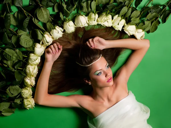 Chica yacía entre las flores de rosas — Foto de Stock