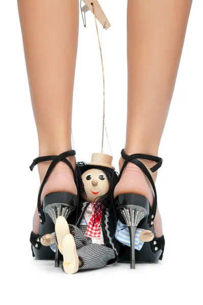 Zabawka pacynka siedzi w pobliżu stopy kobiety — Zdjęcie stockowe