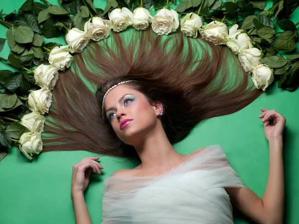 Meisje lag onder de bloemen van rozen — Stockfoto