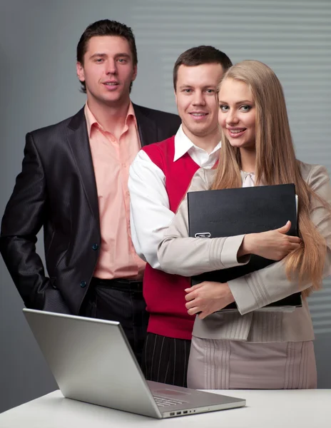 Zwei Männer und eine Frau, die mit einem Computer arbeiten — Stockfoto