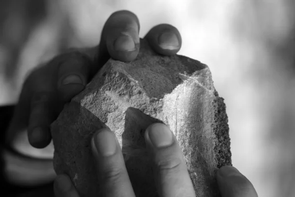 As mãos de um homem com uma pedra — Fotografia de Stock