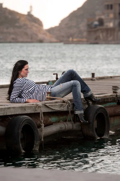 海のバック グラウンドで桟橋に横たわる女 — ストック写真