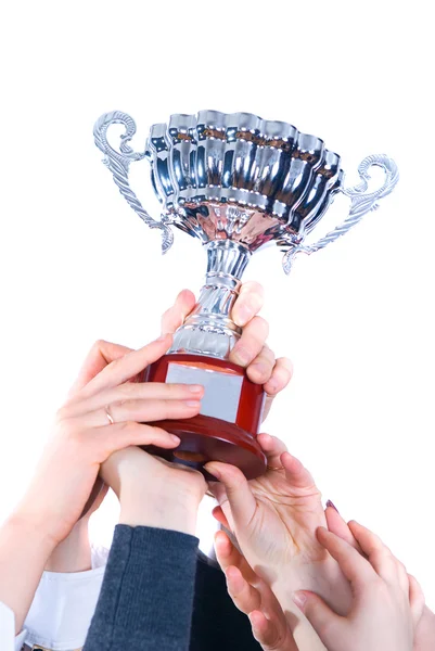Prijs-winnende cup in handen van een opdracht Stockfoto