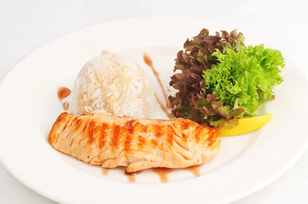 Смажений лосось з рисом та салатом — стокове фото
