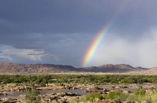 stock image Rainbow and clouds over a river valley