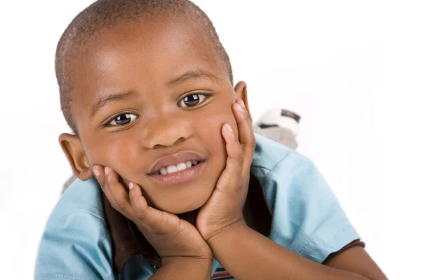 Rozkošný 3 letý černý nebo afrických amerických chlapec leží s rukou na bradě Stock Obrázky