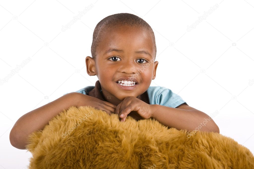 Adorable 3 year old black or African American boy with a toy bear smiling