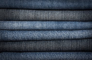 A pile of different types of blue denim jeans closeup clipart