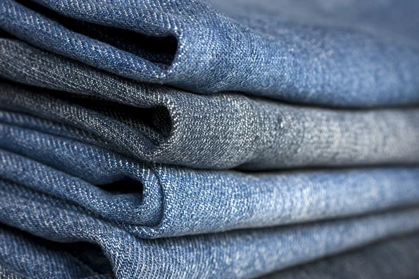 En hög med olika typer av blå denim jeans närbild — Stockfoto
