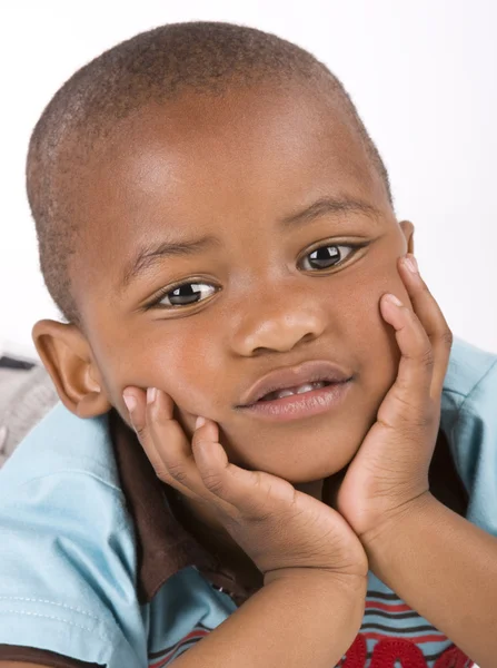 Очаровательный 3-летний черный или афроамериканец, улыбающийся руками на подбородке — стоковое фото