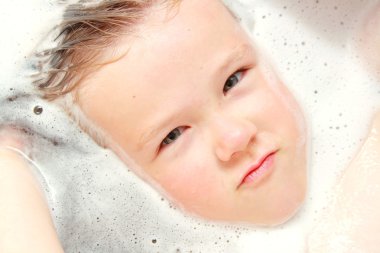 Young child is lying in bath tub