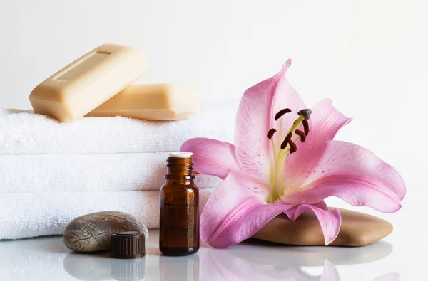 Essential oil, soap, lily, towels. — Stock Photo, Image