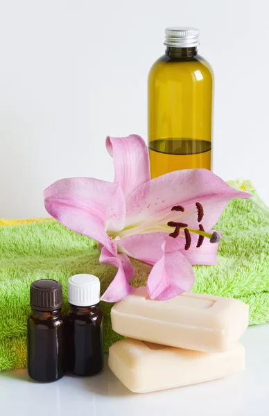 Essential oil, soap, lily, towels — Stock Photo, Image