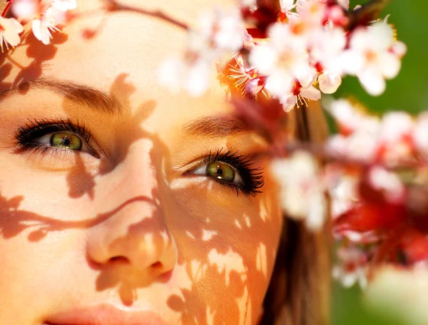 Unga kvinnliga ansikte med blommor — Stockfoto