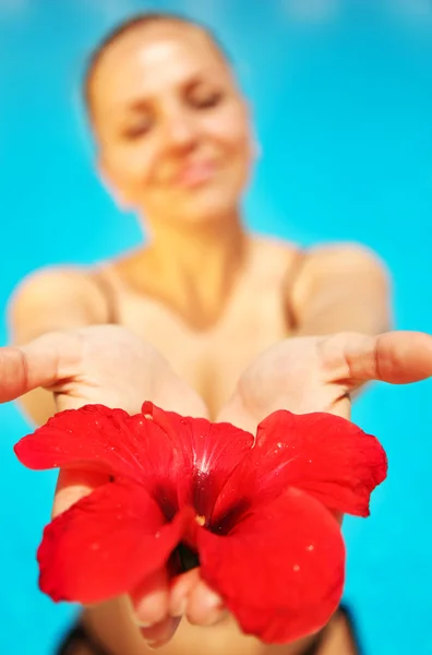 Όμορφη γυναίκα εκμετάλλευση κόκκινο λουλούδι — Φωτογραφία Αρχείου