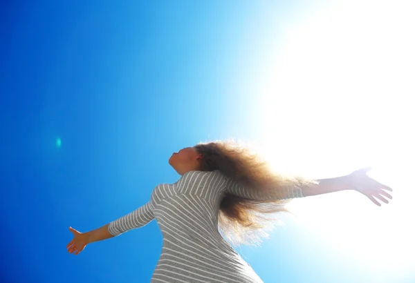 Красивая женщина над голубым чистым небом — стоковое фото
