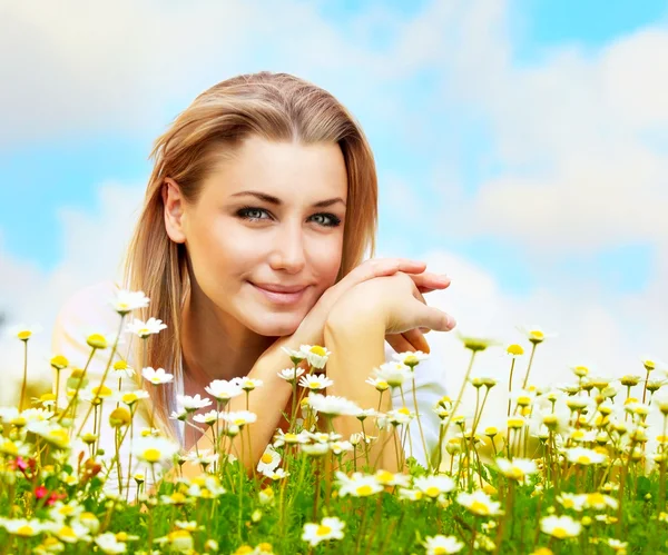 Mooie vrouw de bloem veld opleggen — Stockfoto