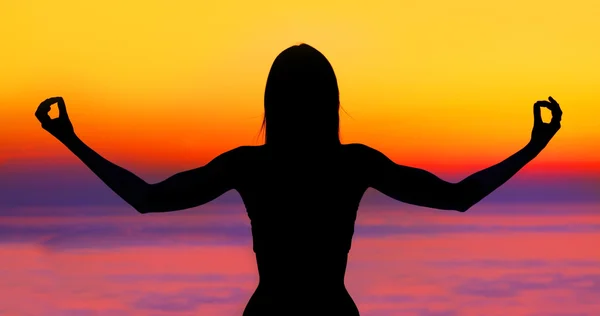 Γιόγκα γυναίκα πάνω από το ηλιοβασίλεμα — Φωτογραφία Αρχείου