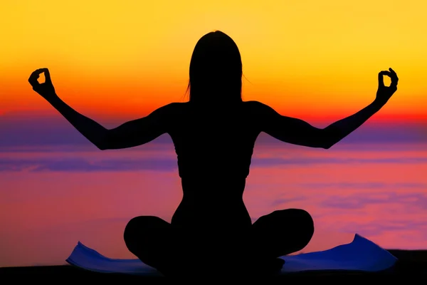 Yoga woman over sunset Stock Picture