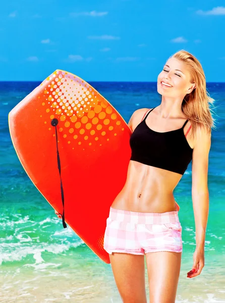 快乐的运动型女孩，在海滩上玩的身体板 — 图库照片