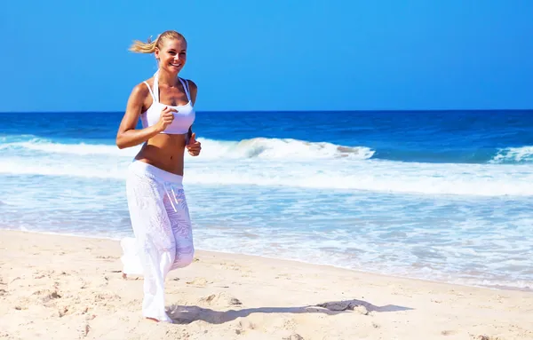 Gezonde vrouw draait op het strand — Stockfoto