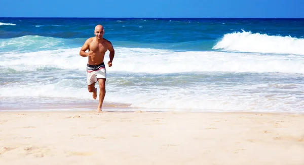 Hombre sano corriendo en la playa — Foto de Stock