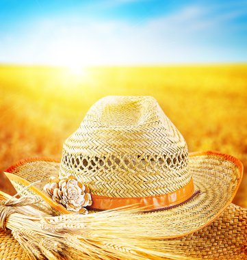 Wheat field and the hat of a farmer clipart