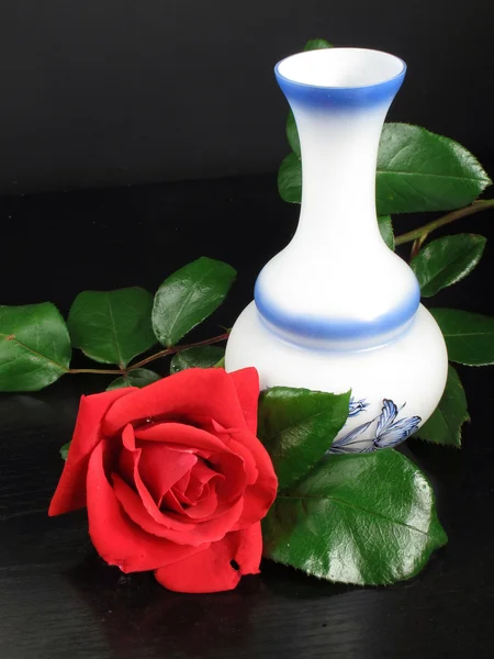 Rosa vermelha bonita com vaso decorado com notas de mesa preta — Fotografia de Stock