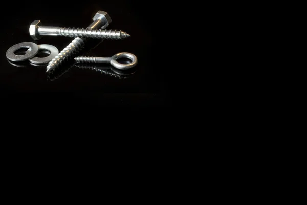Screws and cross on a black background — Stock Photo, Image