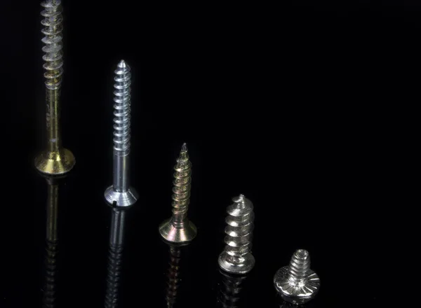 Close five screws of various sizes in scale — Stock Photo, Image