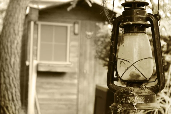 Старая лампа в двери деревянной хижины — стоковое фото