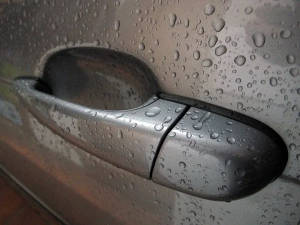 Maçaneta da porta de um carro encharcado em chuva — Fotografia de Stock