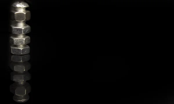 Schrauben und Muttern Detail auf schwarzem Hintergrund — Stockfoto